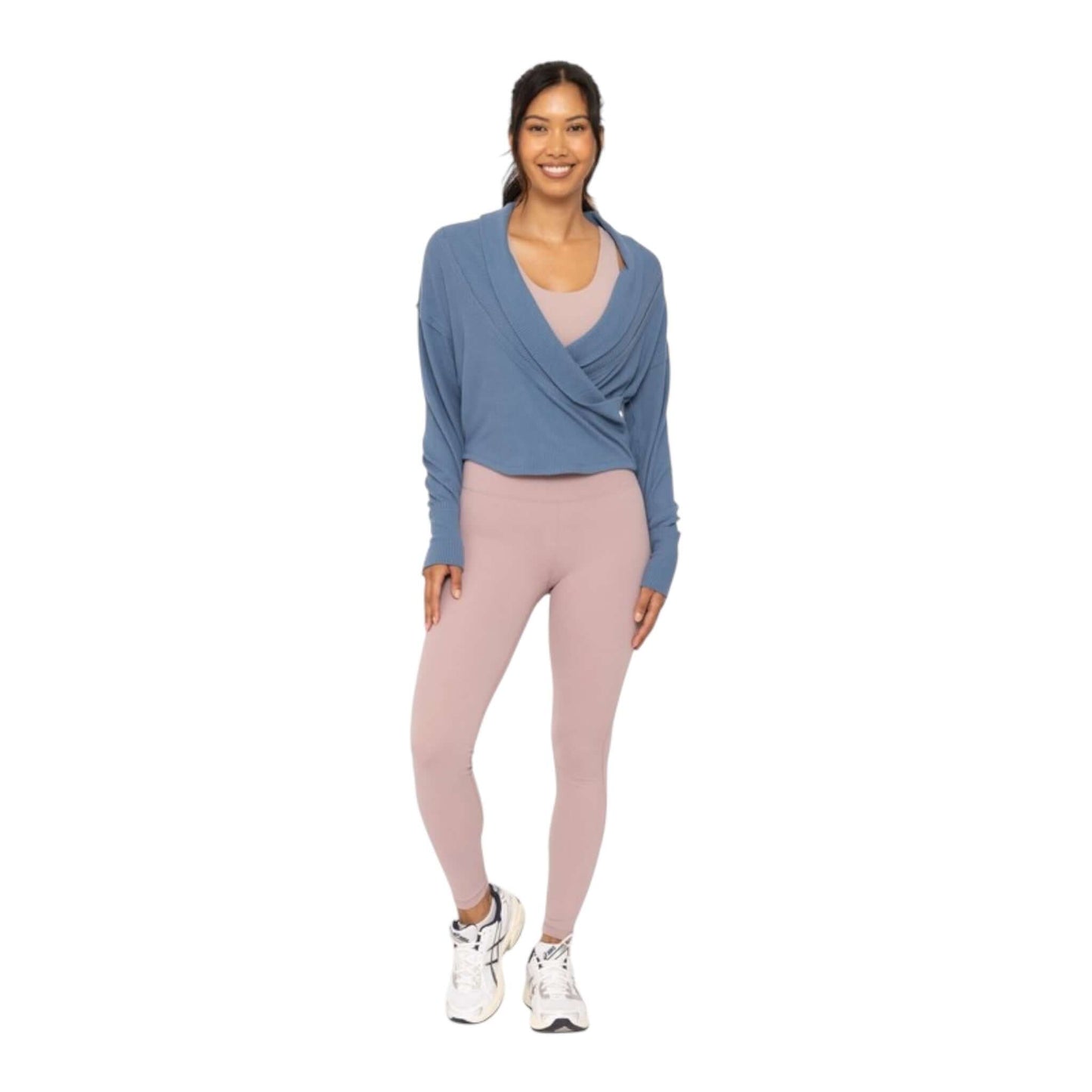 Model wearing a blue ribbed wrap top with pink leggings, showcasing chic activewear style.